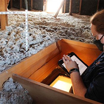 A Home Energy Squad technician assesses an attic