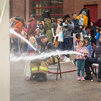 Photo of two small children spraying fire hoses at the HFD Open House